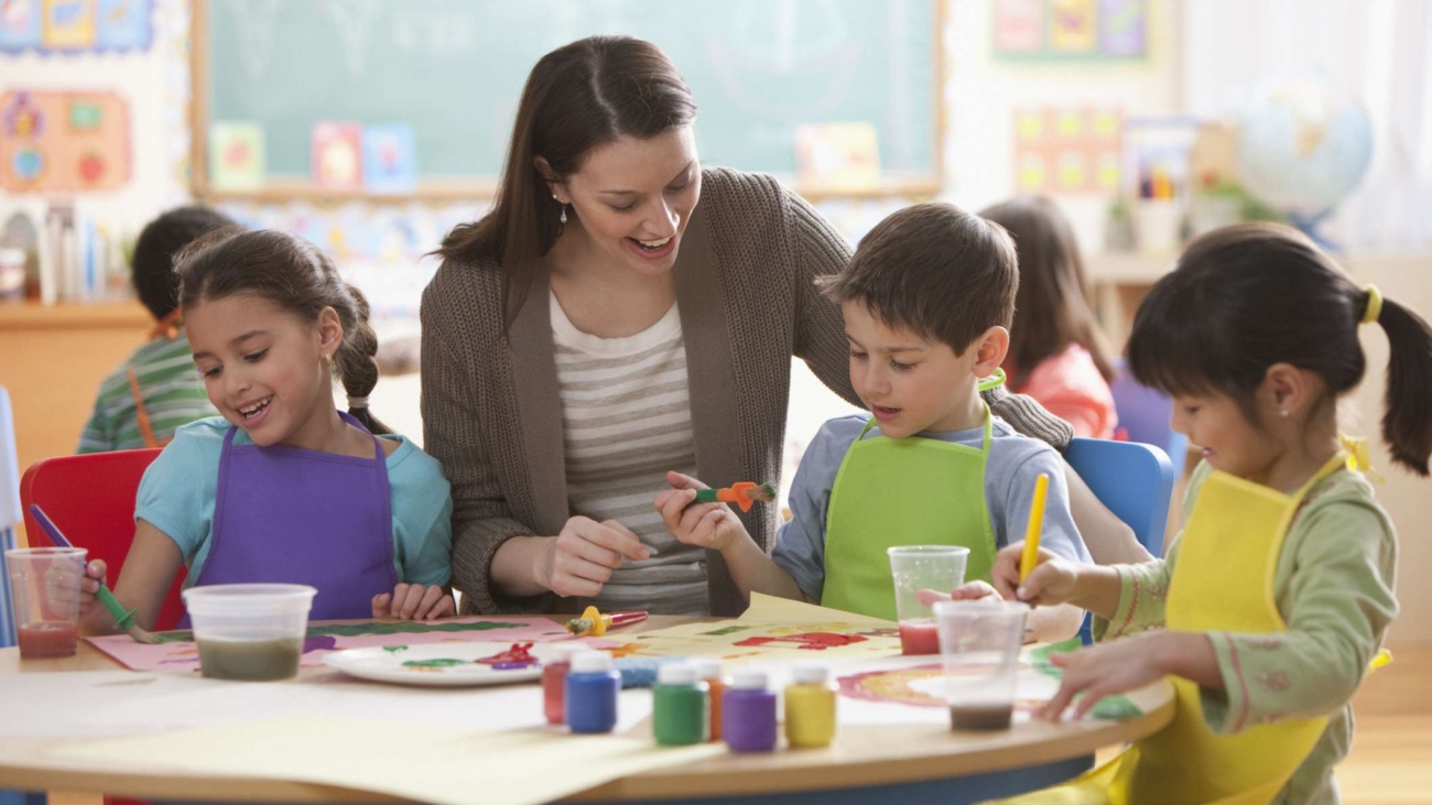 Teacher helping students in art class