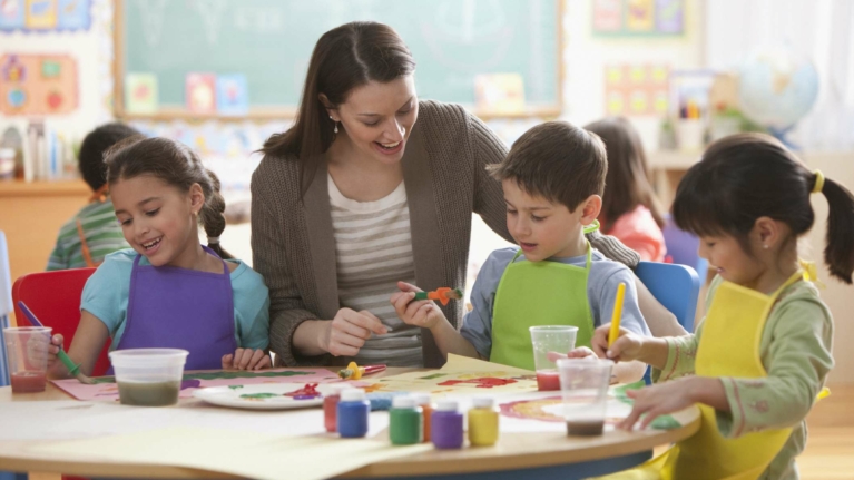 Teacher helping students in art class